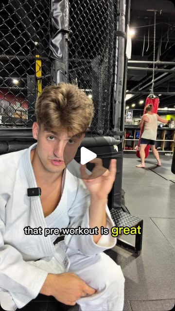Martial artist discussing pre-workout beside the training cage