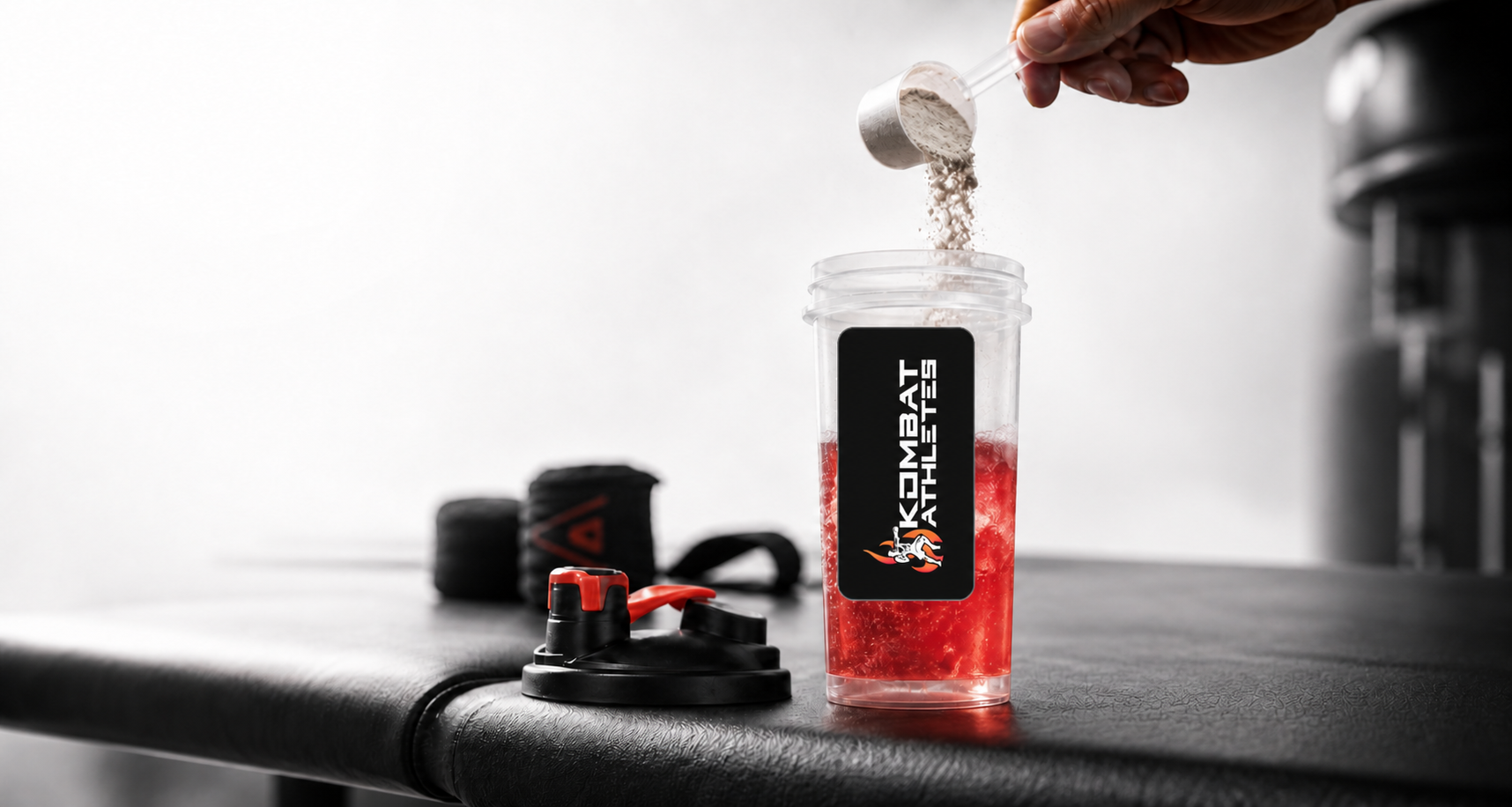 Kombat Juice powder being mixed into a Team Kombat Athletes shaker